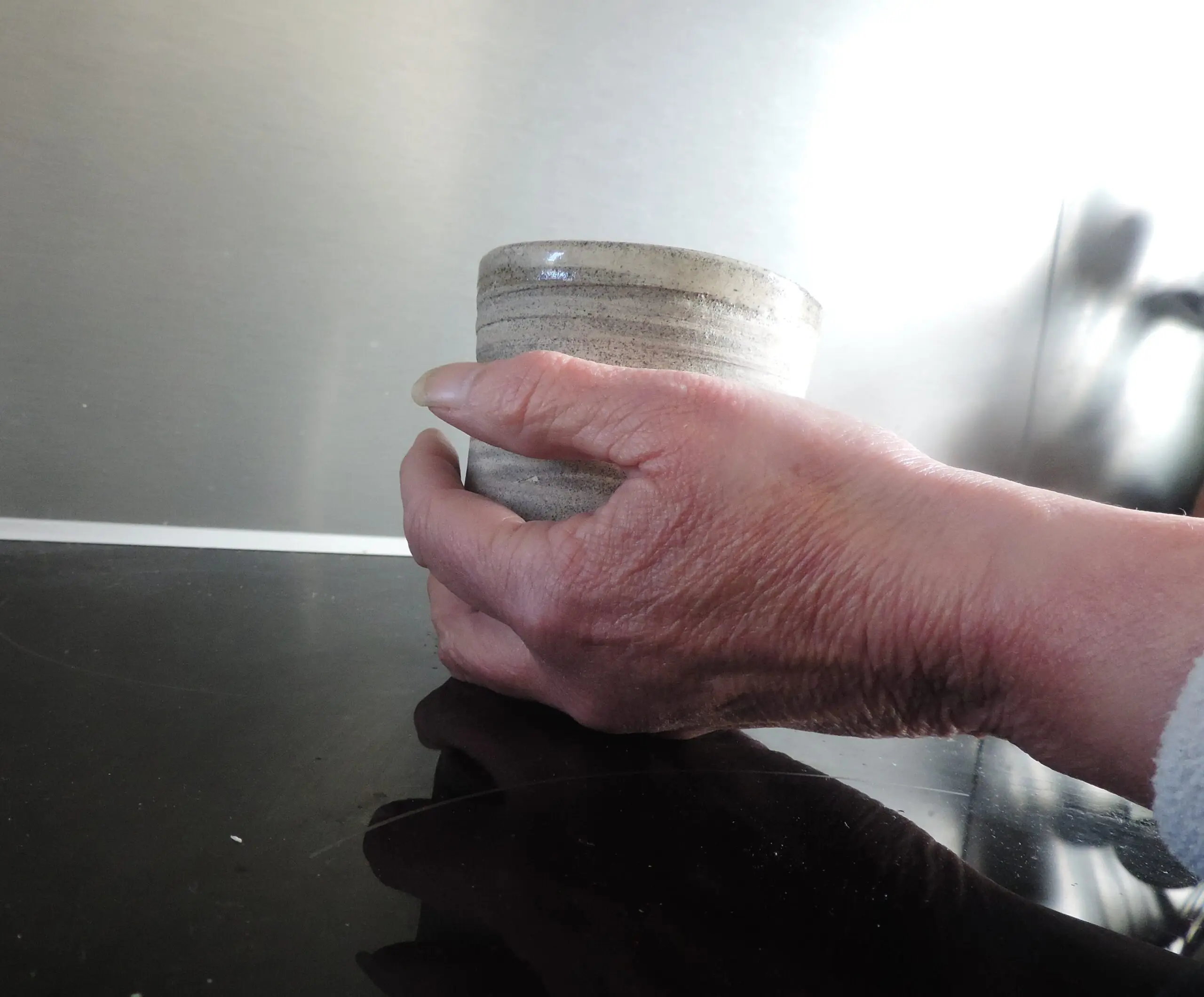Une main tenant un bol de céramique artisanale